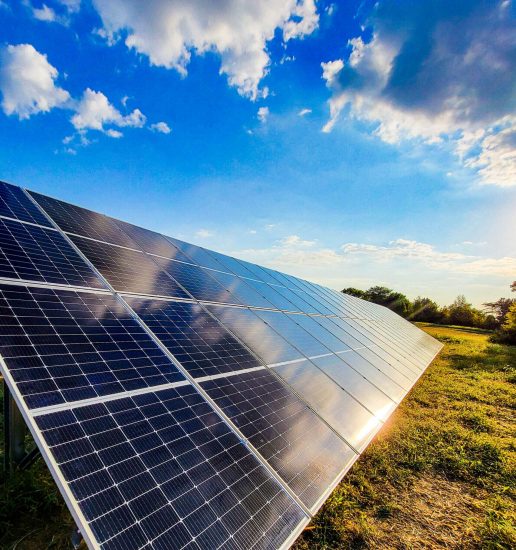 Commercial solar array shining in the sun under blue skies